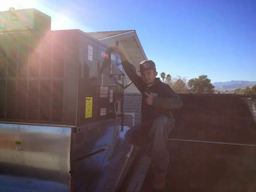 HVAC technician performing Air Duct Repair on a rooftop unit in Chadron